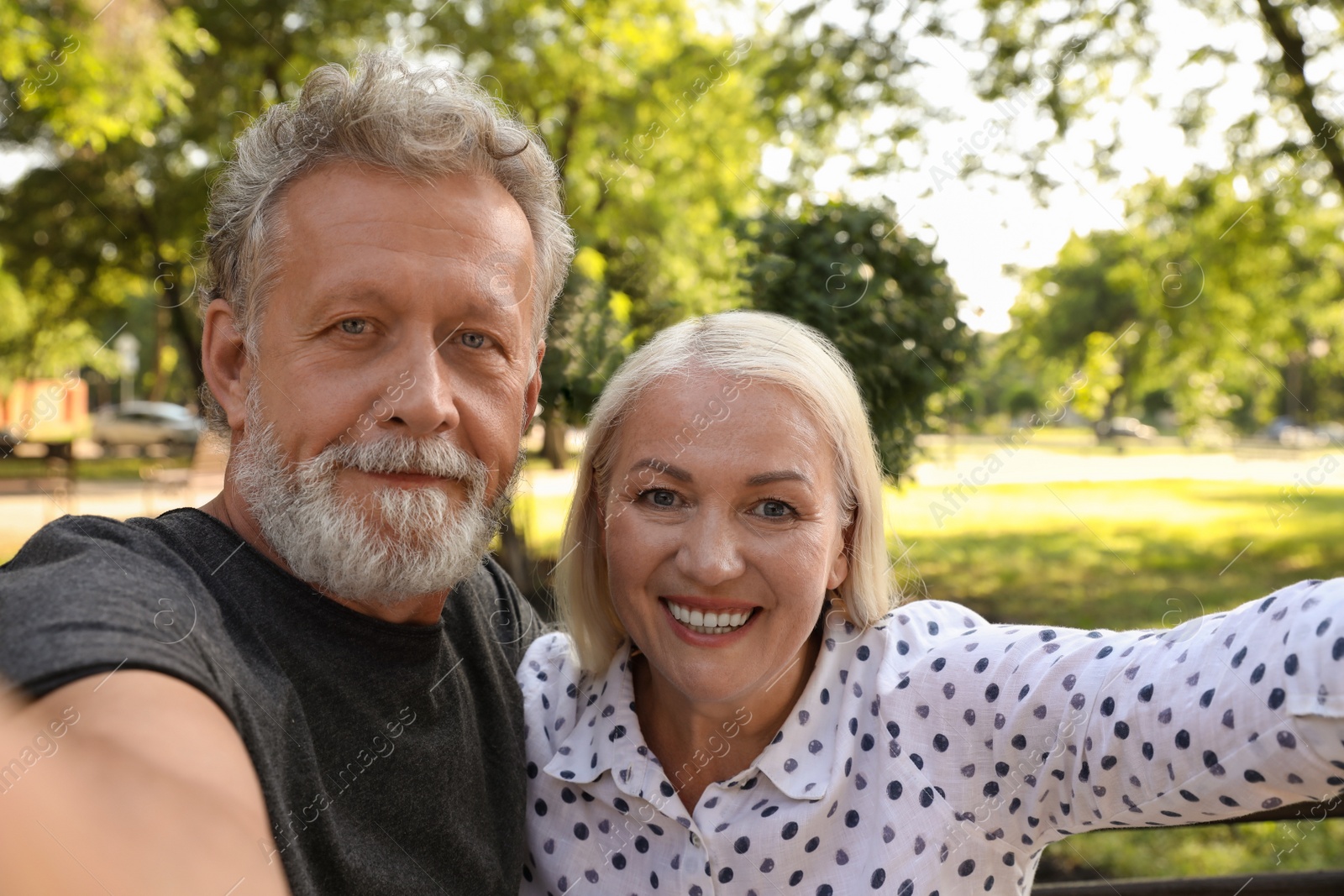 Photo of Lovely mature couple taking selfie in park