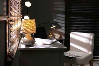 Photo of Stylish room interior with comfortable workplace near window