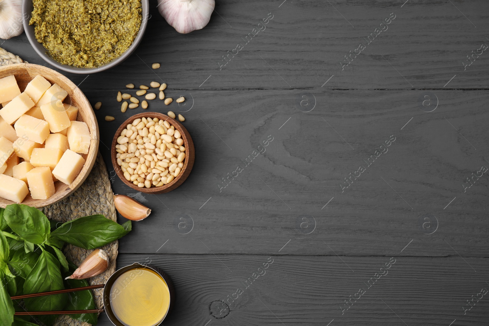 Photo of Different ingredients for cooking tasty pesto sauce on grey wooden table, flat lay. Space for text