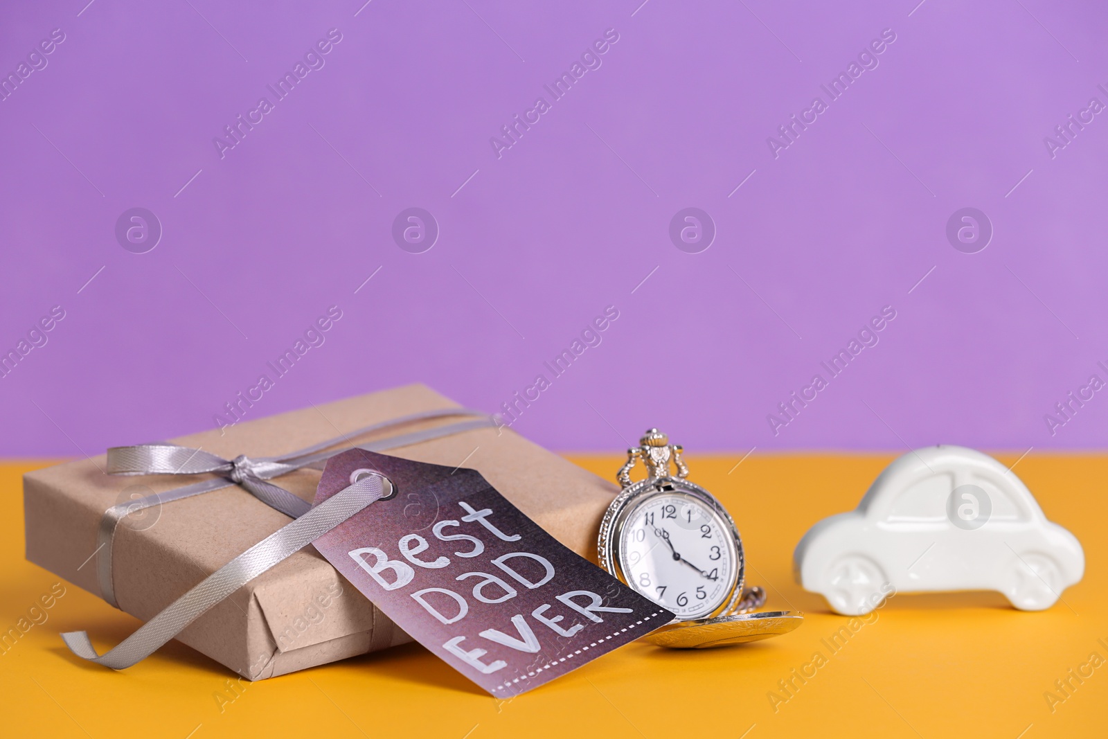 Photo of Composition with gift box and clock on table. Father's day celebration