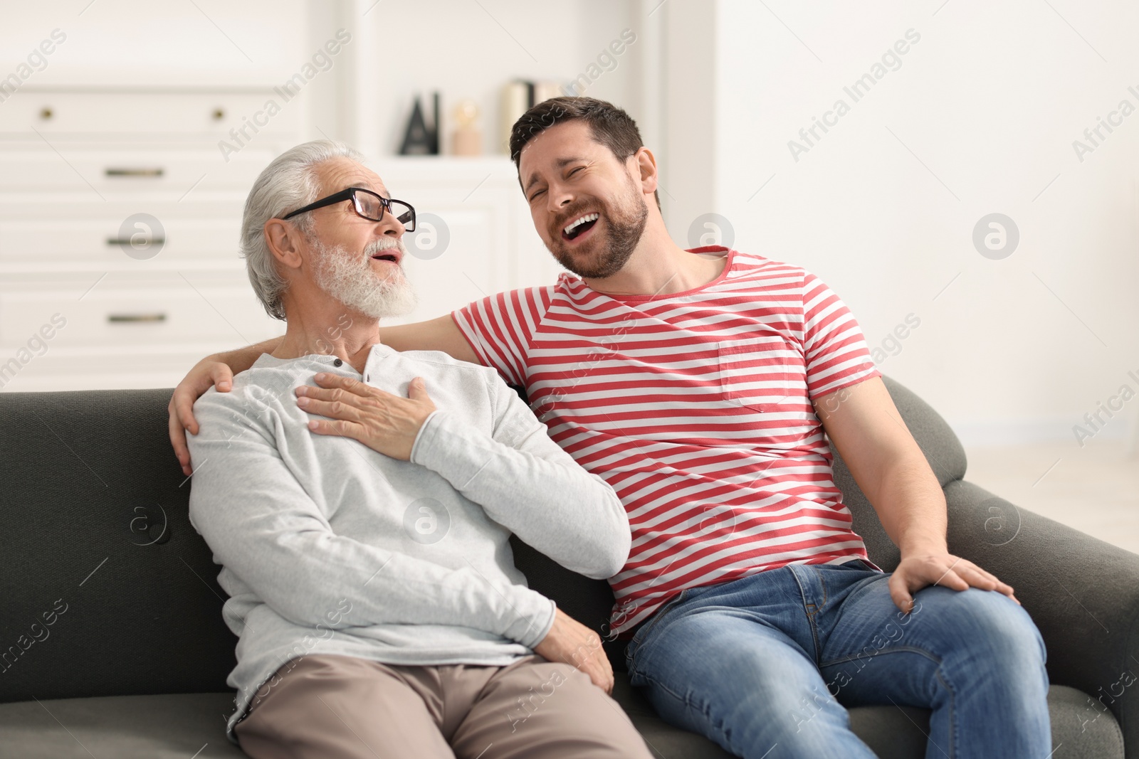 Photo of Happy son and his dad spending time together at home