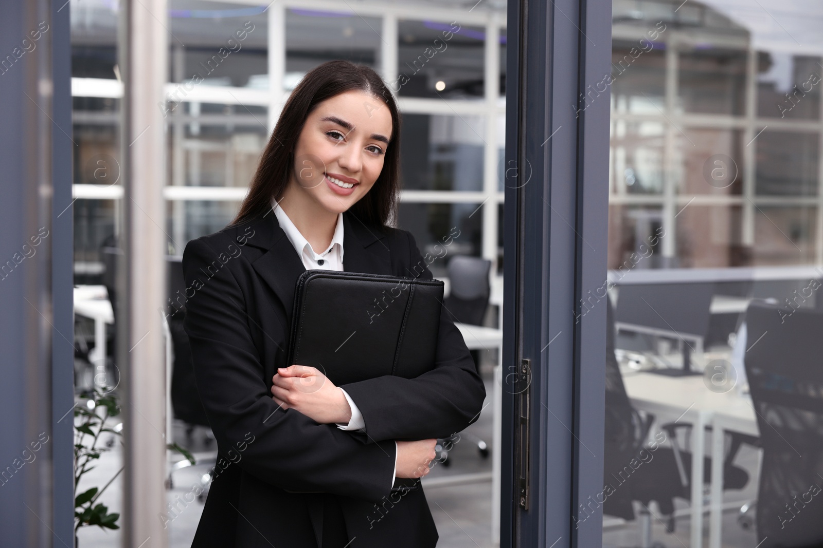 Photo of Female real estate agent with leather portfolio in office