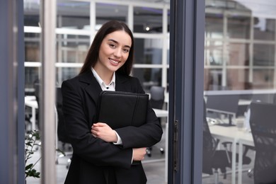 Female real estate agent with leather portfolio in office
