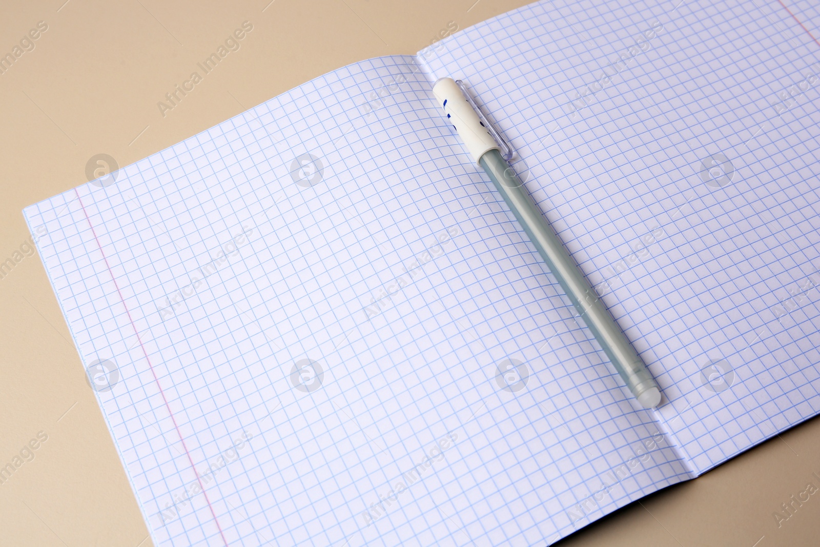 Photo of Copybook with erasable pen on beige background