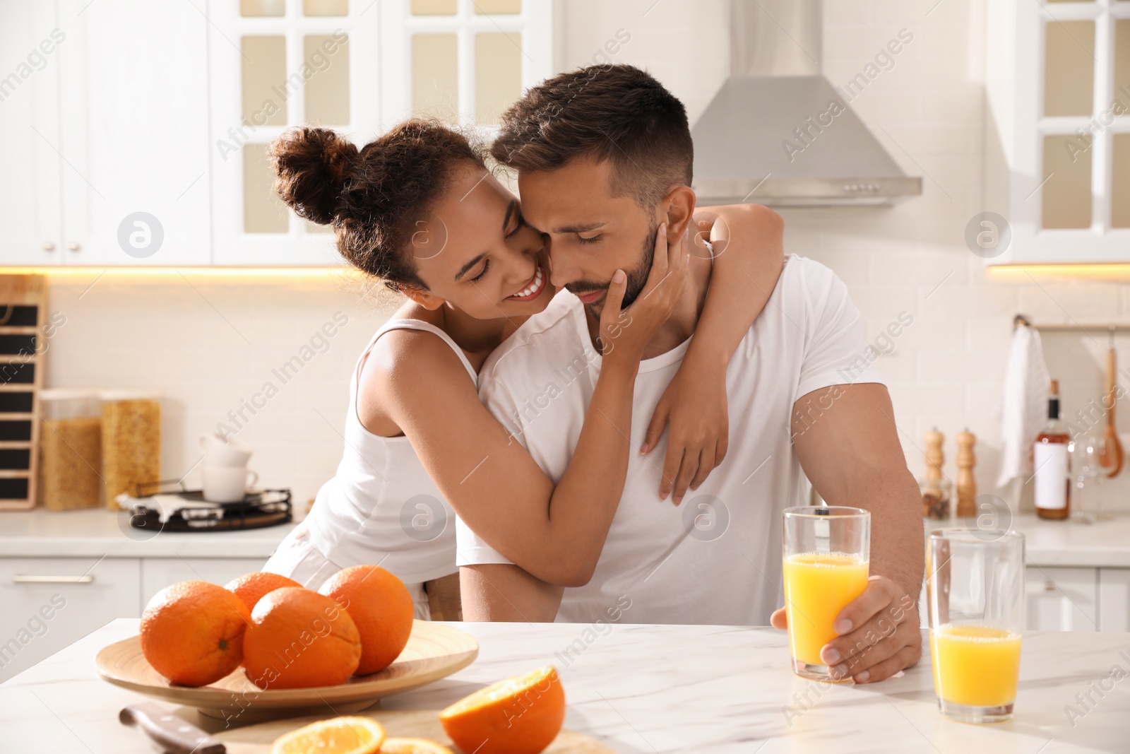 Photo of Lovely couple enjoying time together during breakfast at table in kitchen