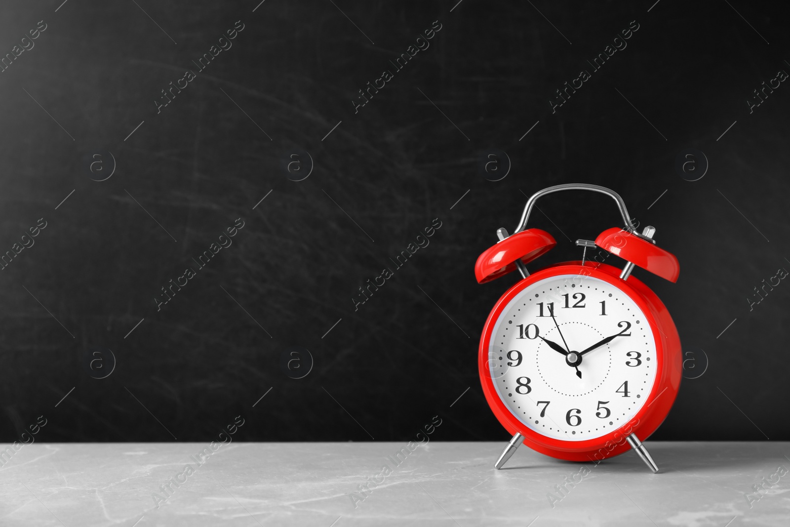 Photo of Alarm clock on table against color background. Time concept