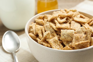 Photo of Bowl of sweet crispy breakfast cereal on table, closeup