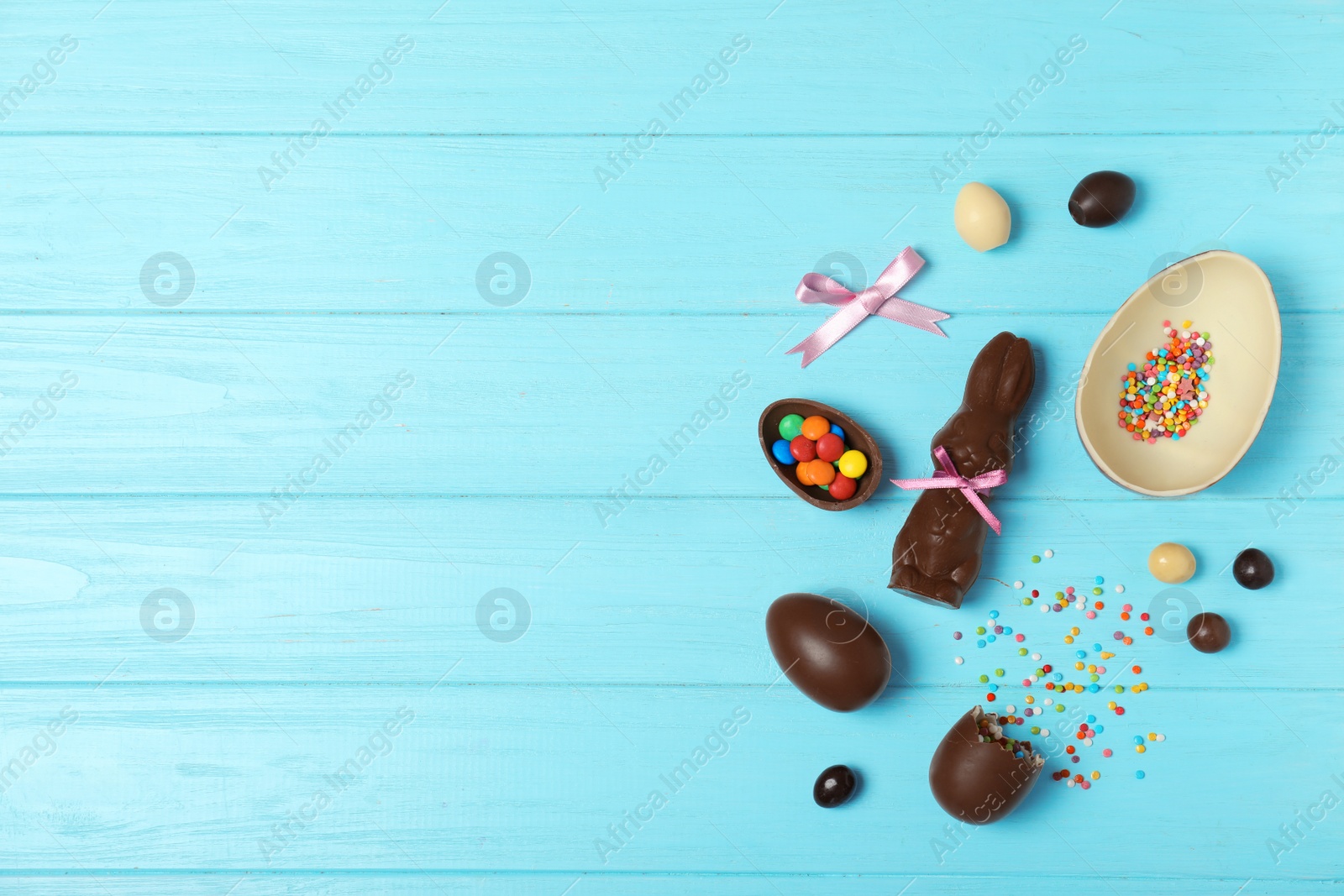 Photo of Flat lay composition with chocolate Easter eggs and space for text on wooden background