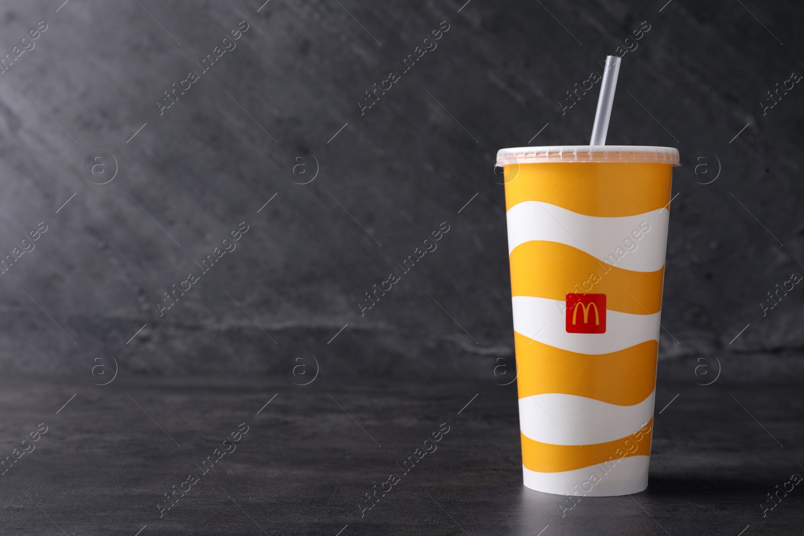 Photo of MYKOLAIV, UKRAINE - AUGUST 12, 2021: Cold McDonald's drink on grey table. Space for text