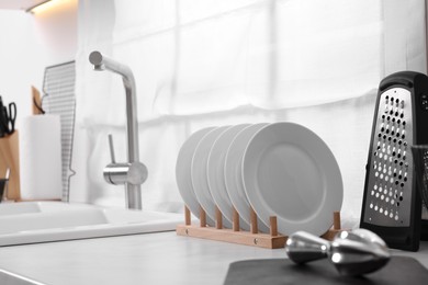 Set of different utensils near sink on countertop in kitchen. Space for text