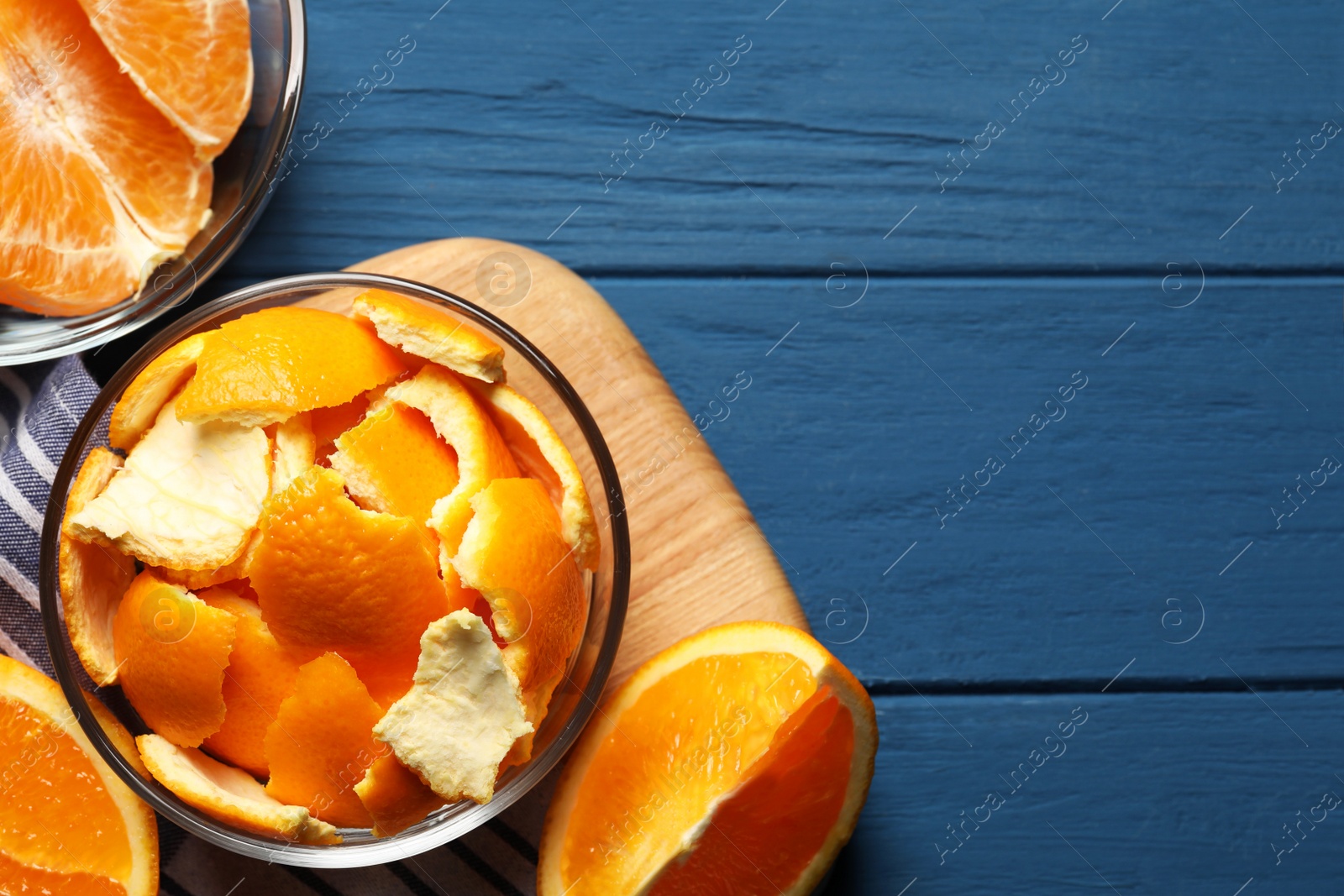 Photo of Orange peels preparing for drying and fresh fruits on blue wooden table, flat lay. Space for text