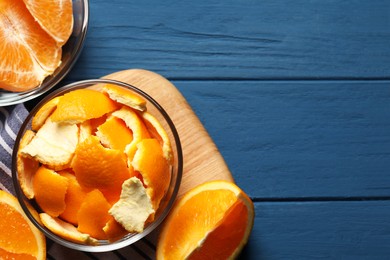 Orange peels preparing for drying and fresh fruits on blue wooden table, flat lay. Space for text