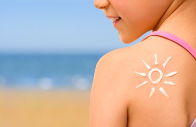 Image of Sun protection. Girl with sunblock on her back near sea, closeup