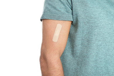 Photo of Man with sticking plaster on arm against white background, closeup
