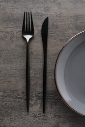 Photo of Stylish cutlery and plate on grey table, top view