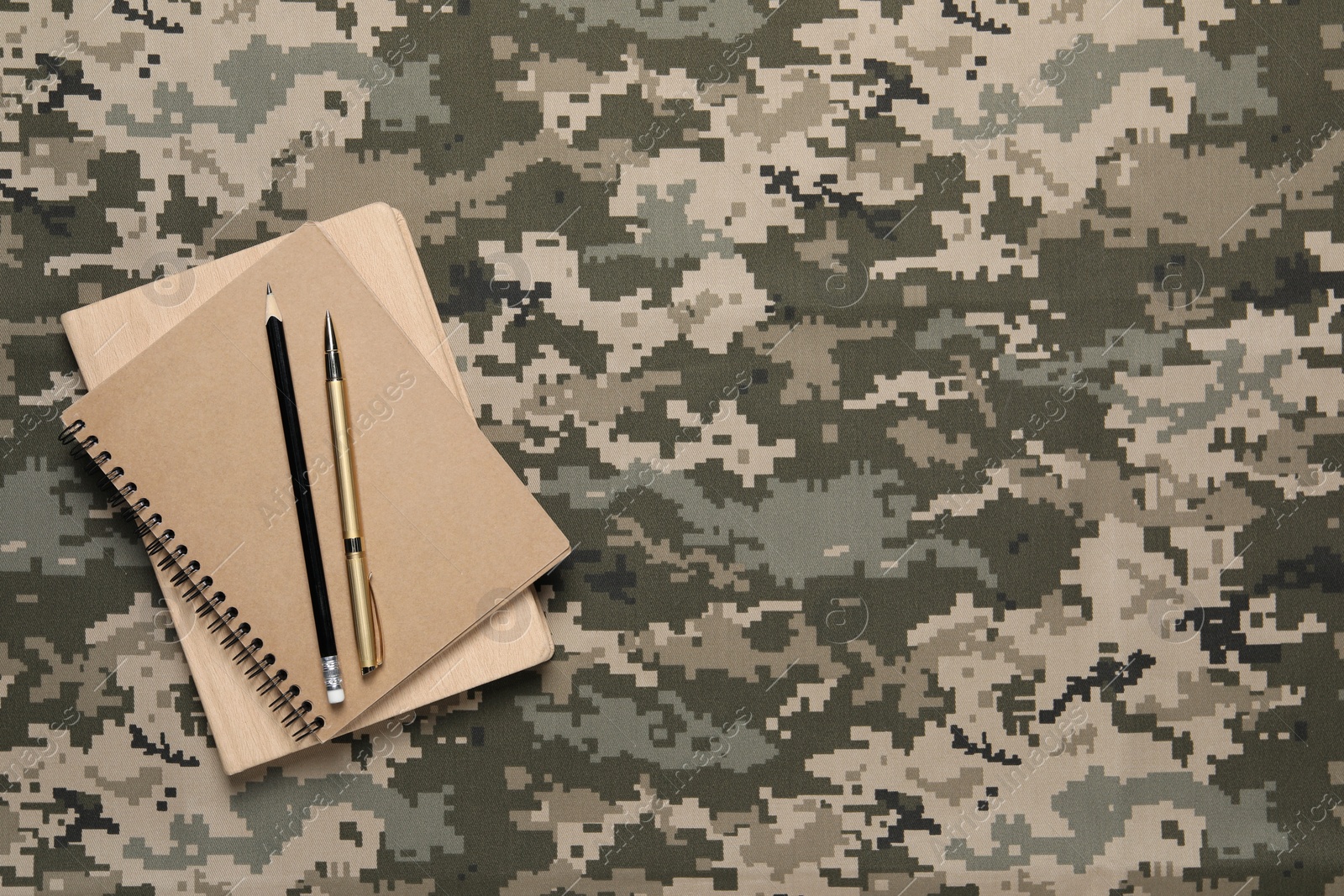 Photo of Notebooks, pen and pencil on camouflage background, top view with space for text. Military education