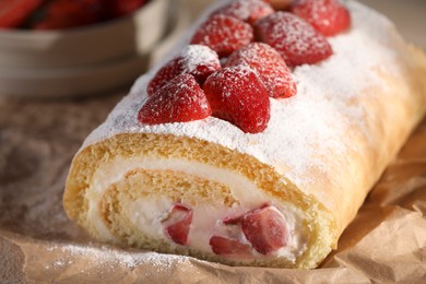 Photo of Delicious cake roll with strawberries and cream on parchment paper, closeup