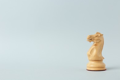 Photo of Wooden knight on light background, space for text. Chess piece