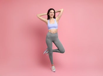 Photo of Happy young woman with slim body posing on pink background