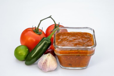 Delicious salsa sauce and ingredients on white background