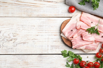 Photo of Flat lay composition with sliced raw bacon on white wooden table. Space for text