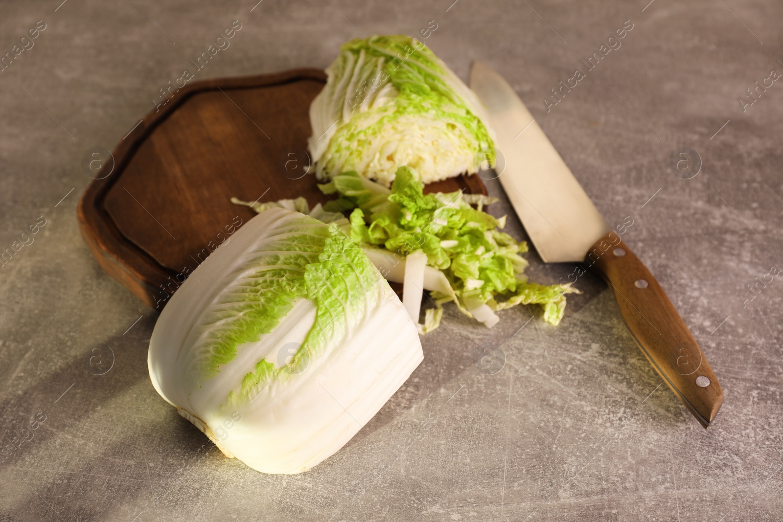 Photo of Cut fresh Chinese cabbage and knife on light grey table