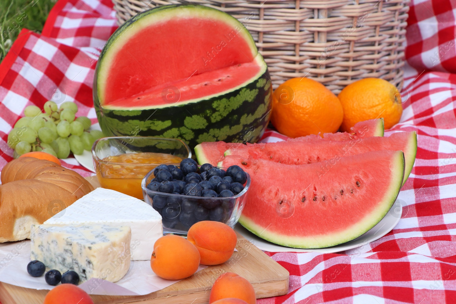 Photo of Picnic blanket with delicious food outdoors on summer day