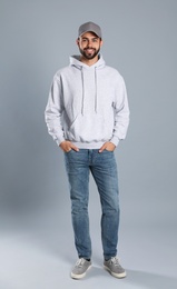 Photo of Full length portrait of young man in sweater on grey background. Mock up for design