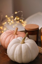 Photo of Pumpkins and candle on wooden board indoors