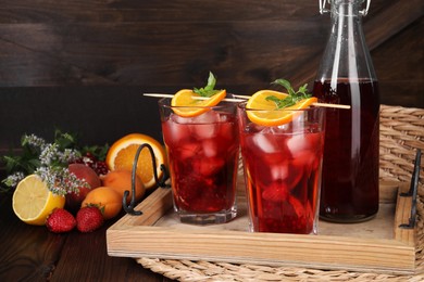 Photo of Delicious refreshing sangria, fresh fruits and berries on wooden table