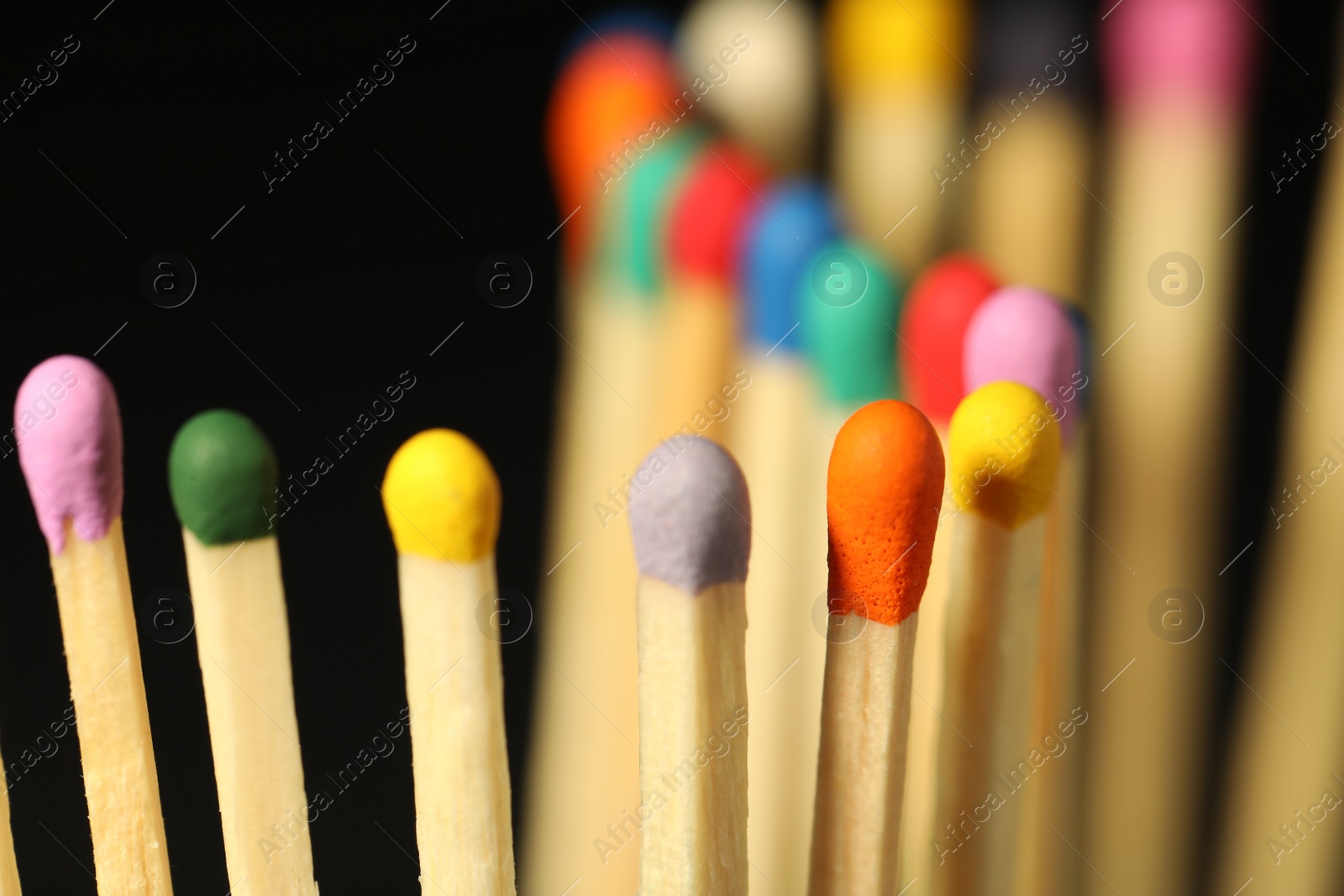 Photo of Matches with colorful heads on black background, closeup