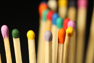 Matches with colorful heads on black background, closeup
