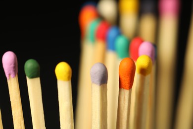 Photo of Matches with colorful heads on black background, closeup