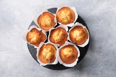 Photo of Delicious sweet muffins on light grey textured table, top view