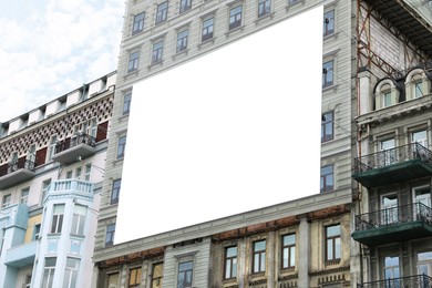 Photo of Blank banner on building facade outdoors. Advertising board design