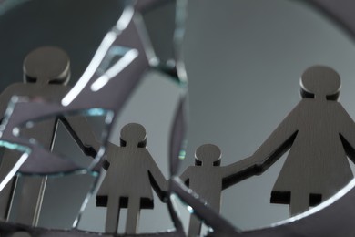 Human figures reflected in broken mirror on gray background, closeup. Divorce concept