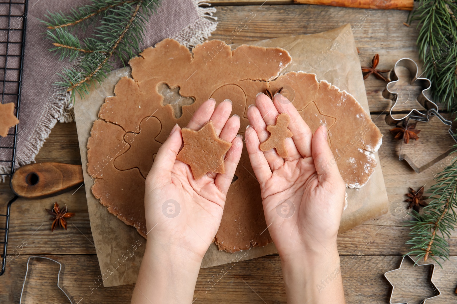Photo of Woman making gingerbread Christmas cookies at wooden table, top view