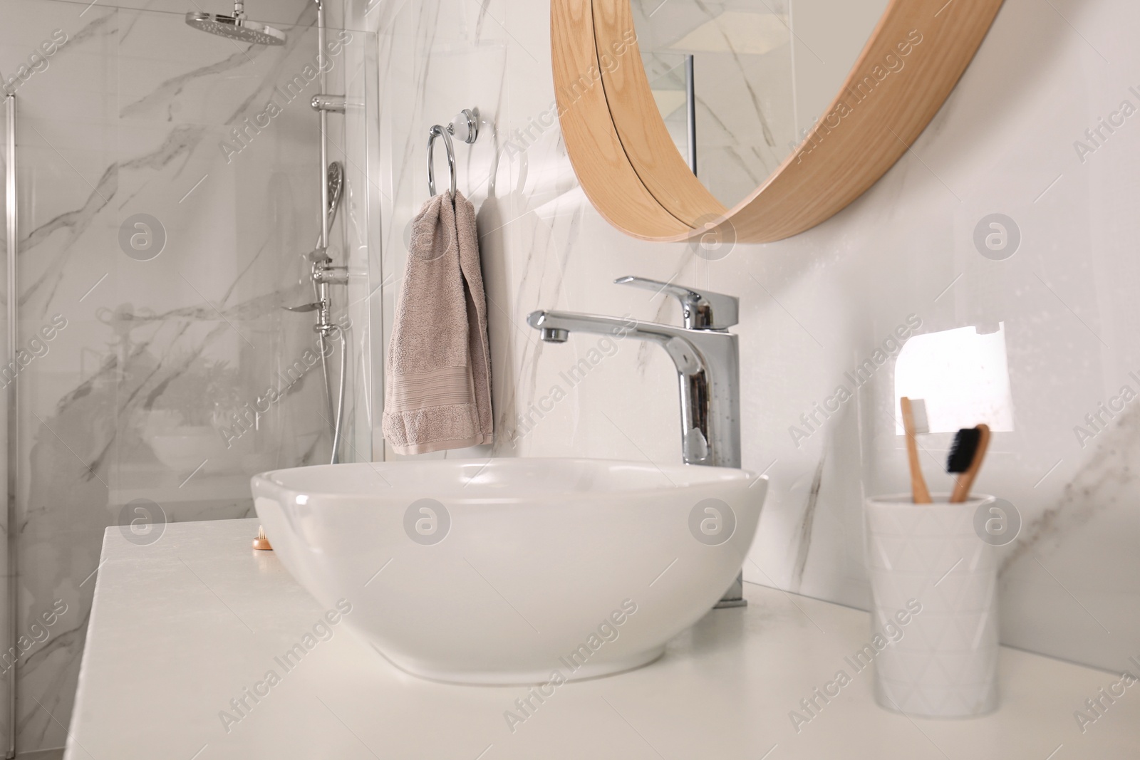 Photo of Bathroom interior with mirror, countertop and soft towel on wall