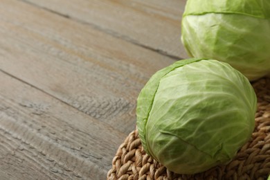 Photo of Ripe white cabbage on wooden table, closeup. Space for text