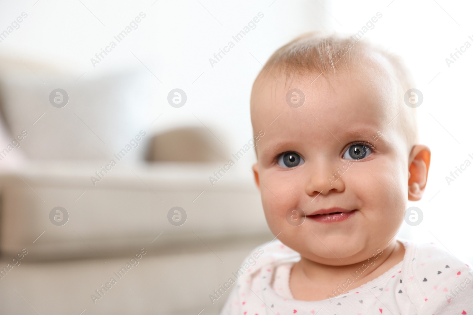 Photo of Portrait of cute baby girl in room. Space for text