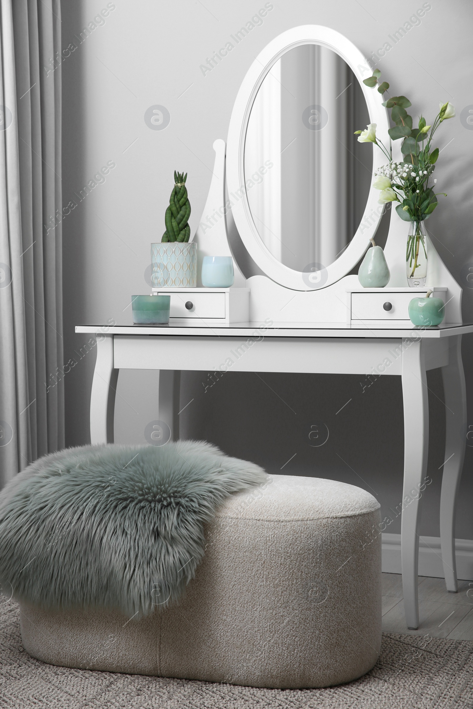 Photo of White dressing table with decor near beige wall in room