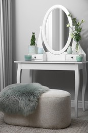 Photo of White dressing table with decor near beige wall in room