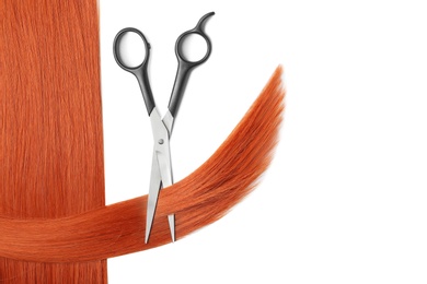 Red hair and scissors on white background, top view. Hairdresser service
