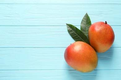 Flat lay composition with mango on color wooden background. Space for text