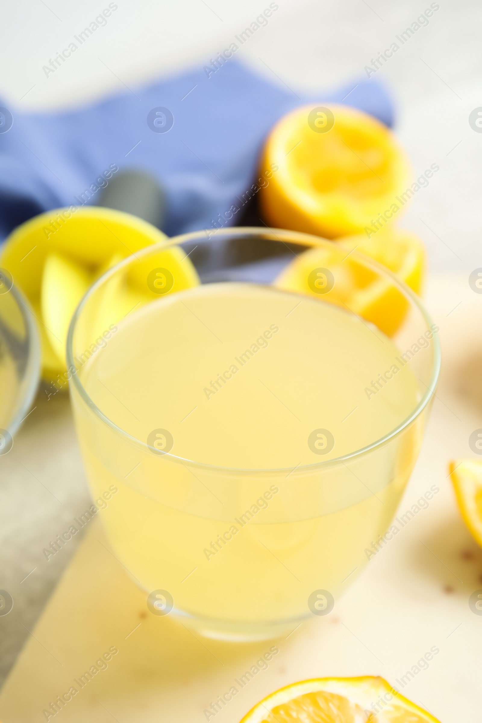 Photo of Freshly squeezed lemon juice in glass on table, closeup