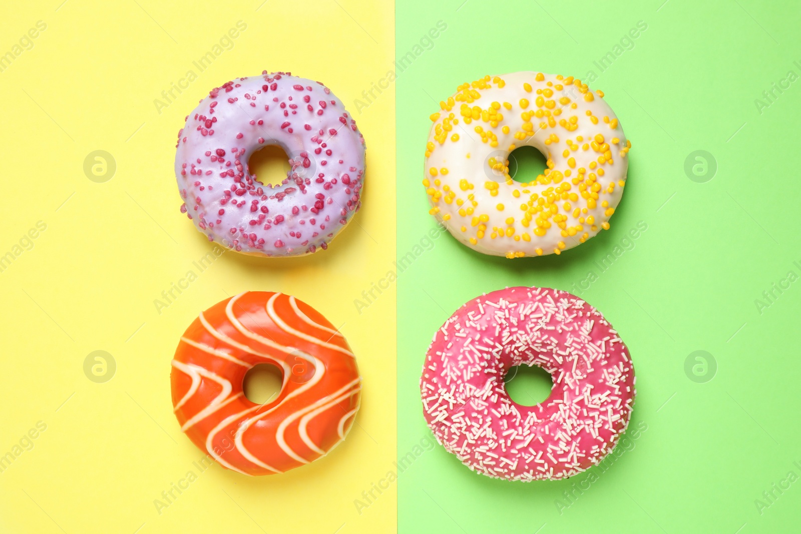 Photo of Delicious glazed donuts on color background, flat lay