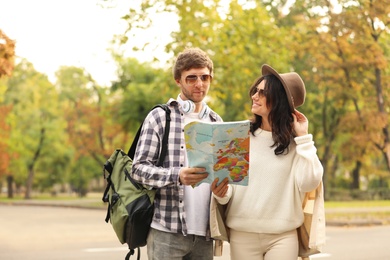 Couple of travelers with map on city street