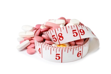 Weight loss pills and measuring tape on white background