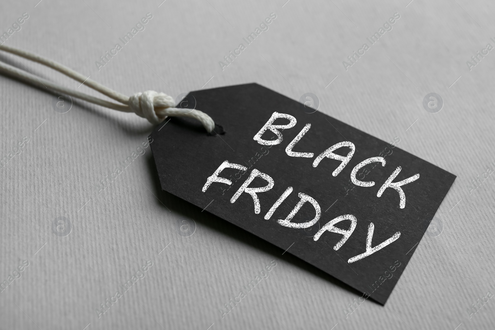Photo of Blank tag on light background, closeup. Black Friday concept