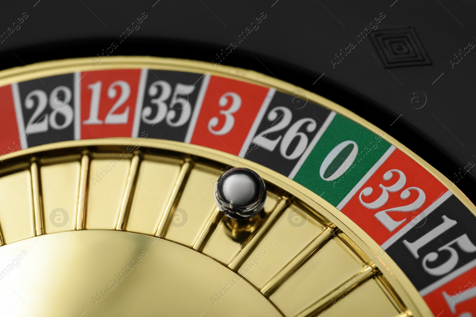 Photo of Roulette wheel with ball, closeup. Casino game